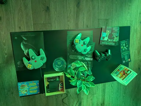 Game controllers and cards laid out on a table under green light