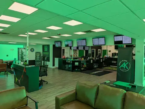 Wide view of the TGI shop floor with couches, counters and green-lit windows